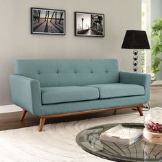 a living room with blue couches and pictures on the wall above it's coffee table