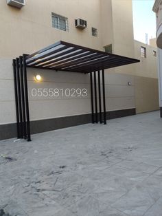 an empty parking lot in front of a building with a metal structure on the ground