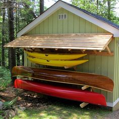 two canoes are attached to the side of a shed