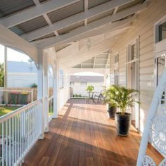 a porch with white railings and wooden floors