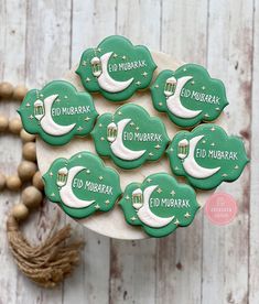 decorated cookies with arabic writing on them sitting on a plate next to beads and tassels