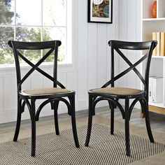 two black chairs sitting next to each other in front of a book shelf and window