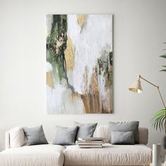 a living room with a white couch and large painting on the wall