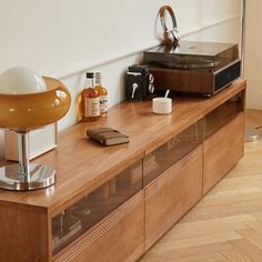 an old record player is sitting on top of a wooden shelf next to other items