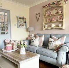 a living room filled with furniture next to a wooden table and wall mounted shelf above it