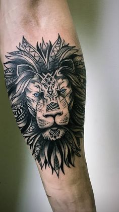 a black and white lion tattoo on the left leg with an intricate pattern around it