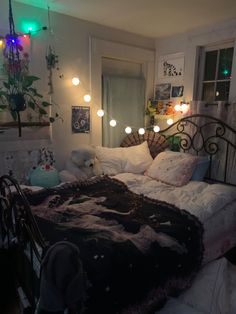 a bedroom with lights on the ceiling and a bed covered in blankets, pillows and blankets