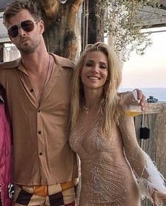 two women and a man are posing for a photo in front of an outdoor bar