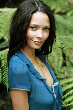 a woman standing in front of green plants