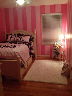 a bedroom with pink and white striped walls