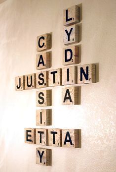 scrabble tiles spelling the names of several cities and towns are arranged on a wall