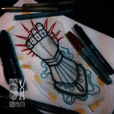 some pens are laying on top of a napkin with an image of a hand holding a lightbulb