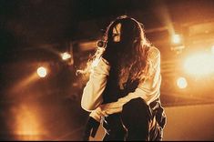 a man with long hair standing on stage