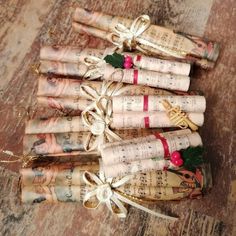 several rolled up newspapers tied with twine and bows on top of wooden flooring