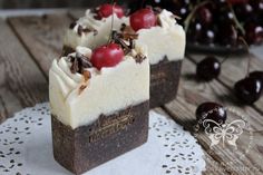 two pieces of cake sitting on top of a white doily next to cherries