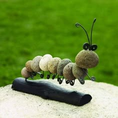 a group of stones sitting on top of a piece of wood next to a stick