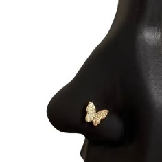 a black mannequin head with a gold butterfly on it's earring