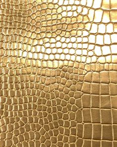 a close up view of an alligator skin pattern on a cell phone case that is gold