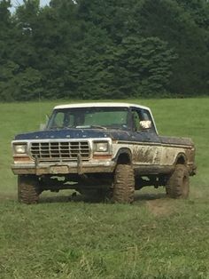 an old pick up truck driving through a field