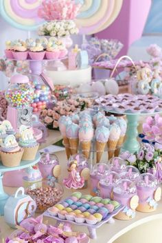 a table topped with lots of cupcakes and cakes