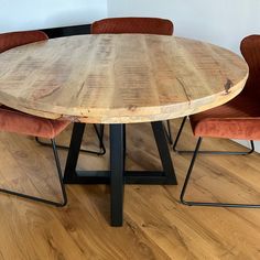 a round wooden table with four chairs around it on a hard wood flooring area