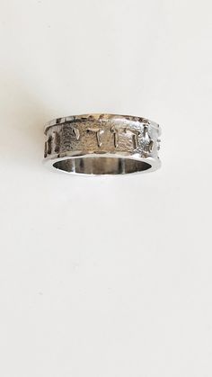 a silver ring with two hearts on the inside and one in the middle, sitting against a white background