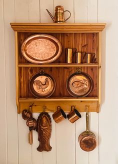 a wooden shelf with pots and pans on it