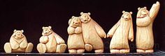 carved wooden bears are lined up in a row