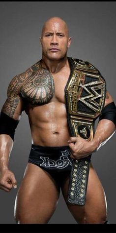 a man with tattoos holding a wrestling belt