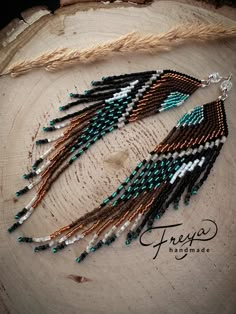 the beaded earrings are hanging from a piece of wood