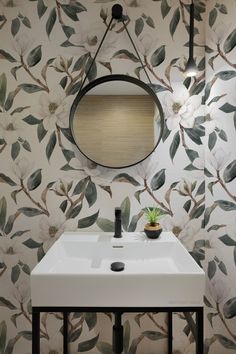 a white sink sitting under a mirror next to a wall mounted faucet in a bathroom