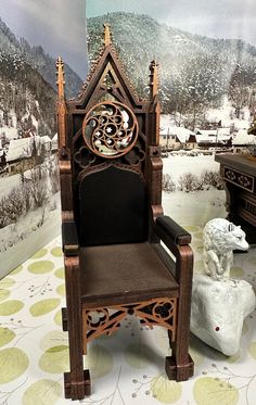 a wooden chair sitting on top of a floor next to a wall with snow covered mountains in the background