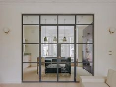 a living room filled with furniture and glass doors