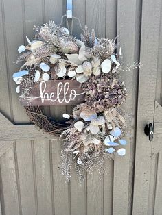 a wreath with the word hello written on it is hanging from a wooden door handle