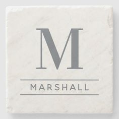 a white marble coaster with the letter m on it's front and side, in black lettering