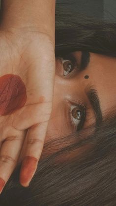 a close up of a person holding their hand over her face with an eye patch on it