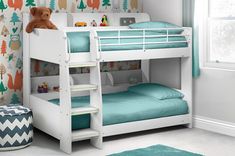 a white bunk bed with blue sheets and a teddy bear sitting on the bottom shelf