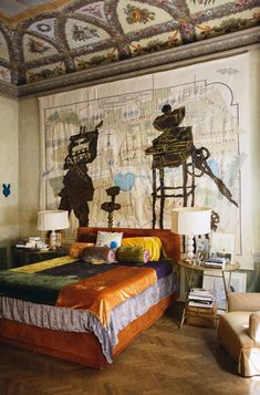 a bedroom with a large painting on the wall above the bed and two lamps next to it