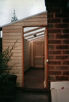 an open door leading to a small wooden building with a skylight on the roof