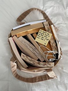 a bag filled with books on top of a bed