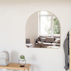 a living room with a couch and mirror on the wall