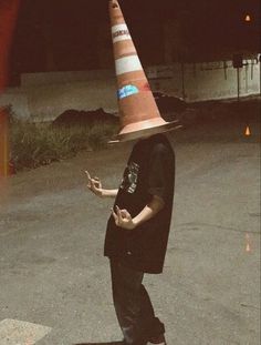 a man wearing a traffic cone hat on top of his head