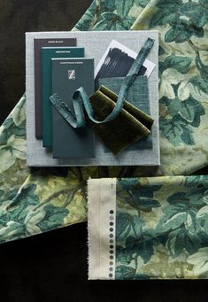 an assortment of green and grey items laid out on top of a floral print table cloth