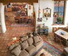 a living room filled with lots of furniture next to a dining room table and chairs