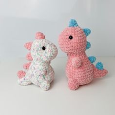 two crocheted stuffed animals sitting next to each other