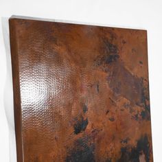 a piece of metal that is rusted and has been painted brown with black spots