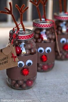 four mason jars with reindeer noses and chocolate candies in them