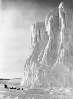 a group of people riding horses next to an ice covered mountain in black and white