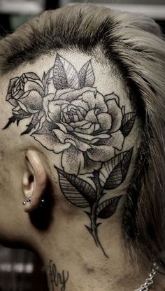 a woman's head with a rose tattoo on the side of her neck and behind her ear