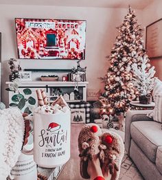 someone is holding their teddy bear in front of the christmas tree and watching tv at night